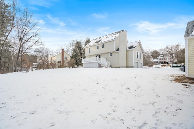 view of snow covered back of property