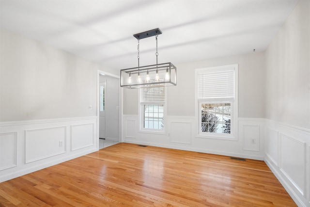 unfurnished dining area featuring light wood-type flooring