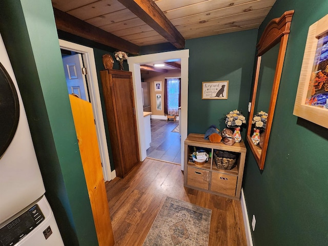 hall with stacked washer and dryer, beam ceiling, wooden ceiling, and dark hardwood / wood-style floors