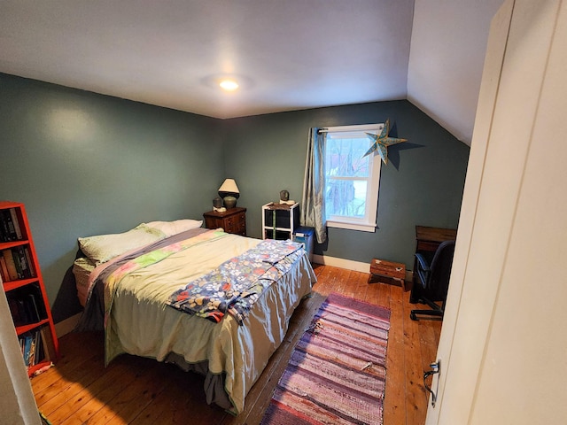 bedroom featuring hardwood / wood-style floors and vaulted ceiling