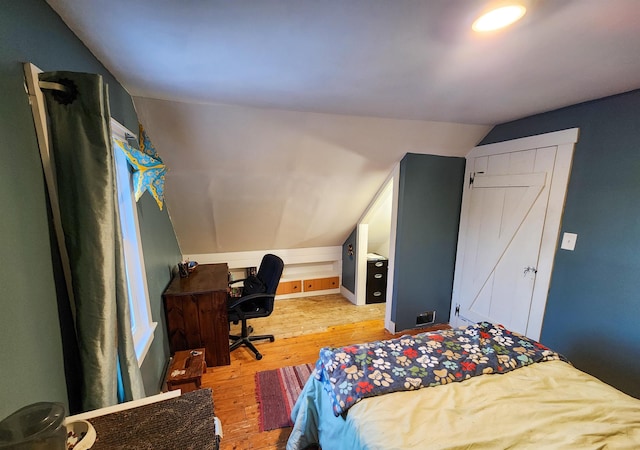 bedroom with lofted ceiling and light hardwood / wood-style flooring