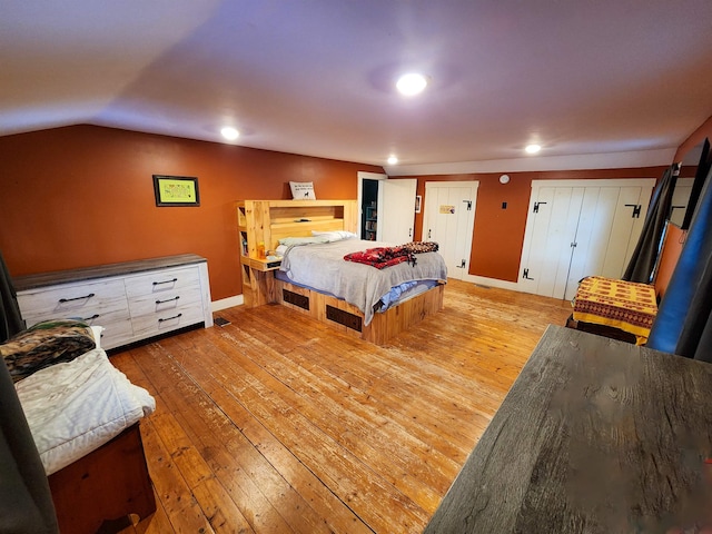 bedroom featuring lofted ceiling and light hardwood / wood-style flooring