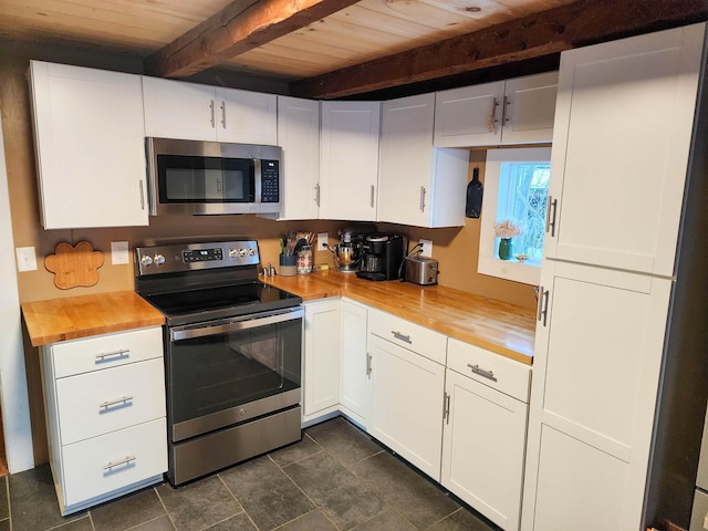 kitchen featuring butcher block counters, white cabinetry, beam ceiling, and stainless steel appliances