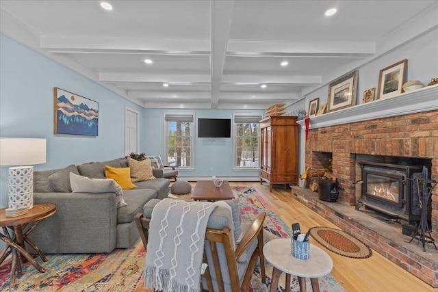 living room featuring coffered ceiling, a fireplace, beam ceiling, and light wood-type flooring