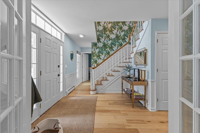 foyer featuring wood-type flooring and a baseboard heating unit