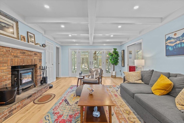 living room with coffered ceiling, beam ceiling, light hardwood / wood-style flooring, and french doors