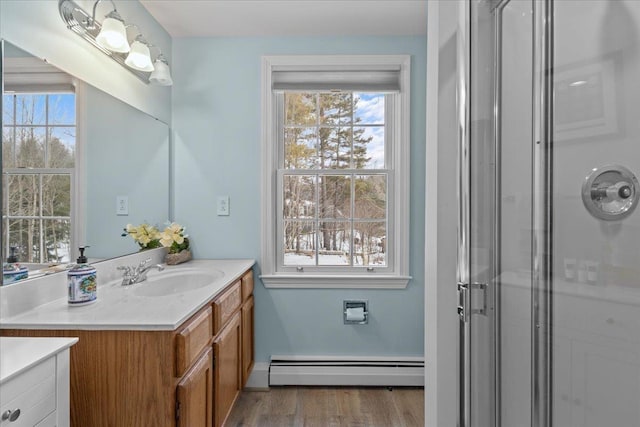 bathroom with baseboard heating, plenty of natural light, an enclosed shower, and vanity