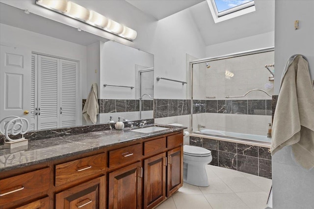 full bathroom featuring tile patterned floors, toilet, vanity, enclosed tub / shower combo, and vaulted ceiling with skylight