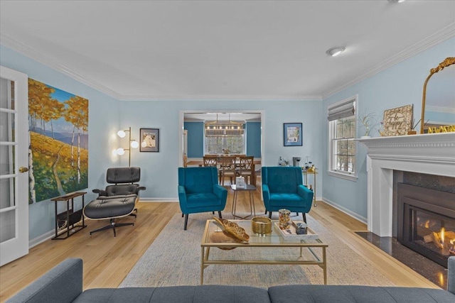 living room with crown molding, plenty of natural light, and light hardwood / wood-style flooring