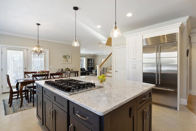 kitchen with pendant lighting, stainless steel appliances, a center island, and dark brown cabinetry