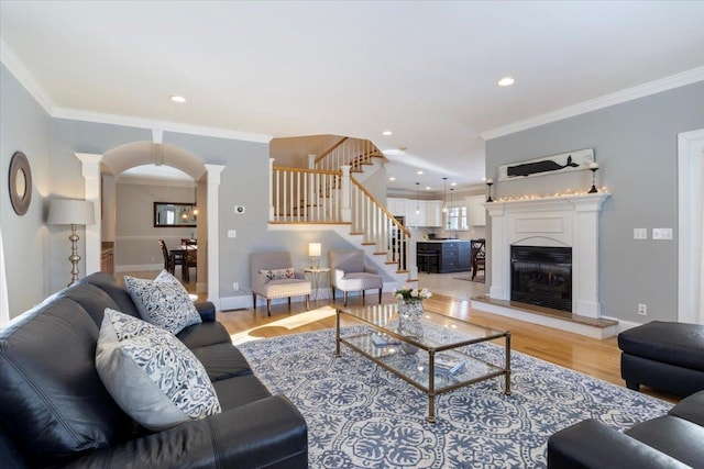 living room with light hardwood / wood-style flooring, ornamental molding, and ornate columns