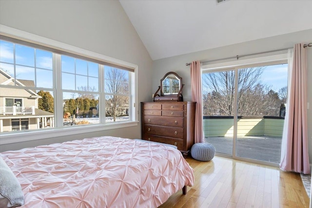 bedroom featuring high vaulted ceiling, access to outside, multiple windows, and light wood-type flooring