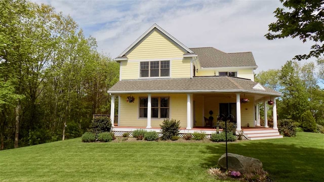 rear view of house featuring a porch and a yard