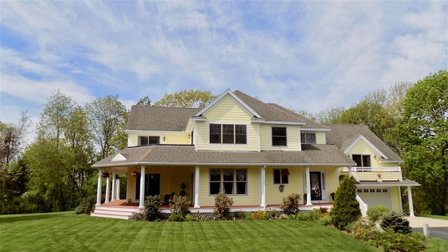 farmhouse inspired home featuring a porch, a garage, and a front yard