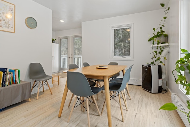 dining room with french doors, baseboard heating, and light hardwood / wood-style floors