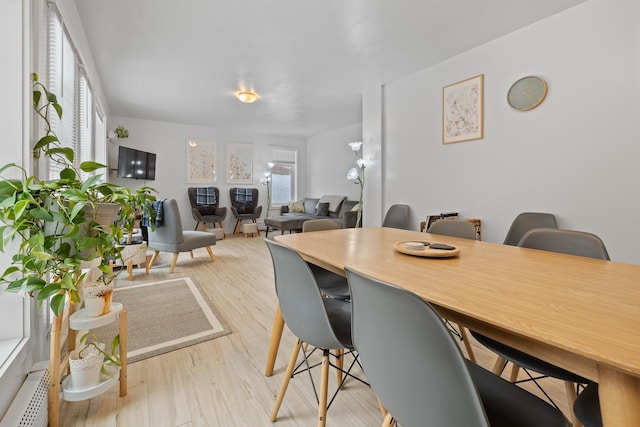 dining area featuring light wood-type flooring and baseboard heating