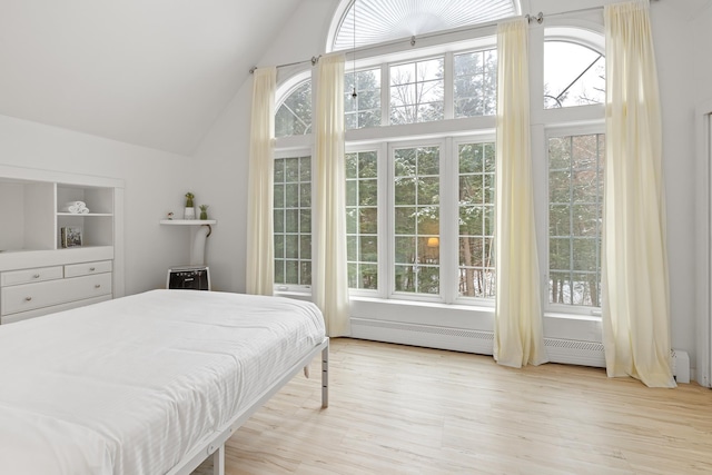 bedroom with high vaulted ceiling and light hardwood / wood-style floors