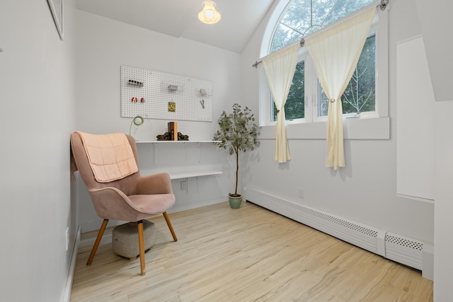 sitting room featuring hardwood / wood-style flooring, a baseboard radiator, and vaulted ceiling