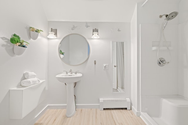 bathroom with walk in shower, a baseboard radiator, and hardwood / wood-style floors