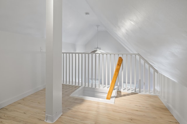 bonus room with lofted ceiling and light wood-type flooring