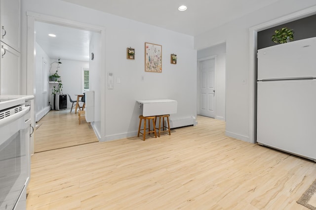 kitchen featuring white cabinets, white appliances, and light hardwood / wood-style floors