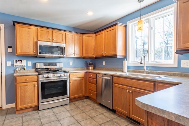 kitchen with sink, decorative light fixtures, and appliances with stainless steel finishes