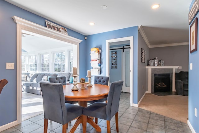 dining area featuring crown molding, carpet, and a fireplace