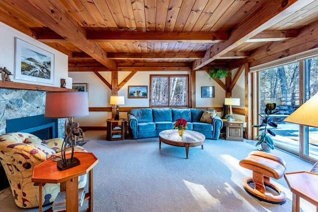 living room featuring wood ceiling, beam ceiling, a stone fireplace, and a wealth of natural light