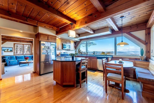 kitchen featuring hanging light fixtures, a kitchen island, light hardwood / wood-style floors, and appliances with stainless steel finishes