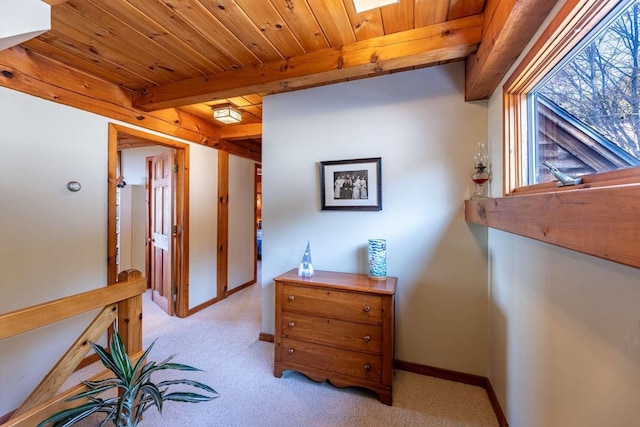 corridor with light carpet, wood ceiling, and beam ceiling