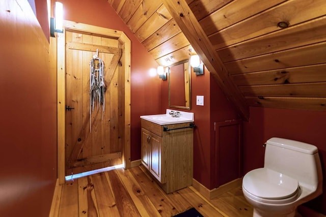 bathroom featuring vaulted ceiling, hardwood / wood-style floors, vanity, wood ceiling, and toilet