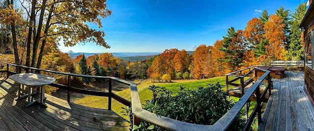 deck featuring a mountain view and a yard