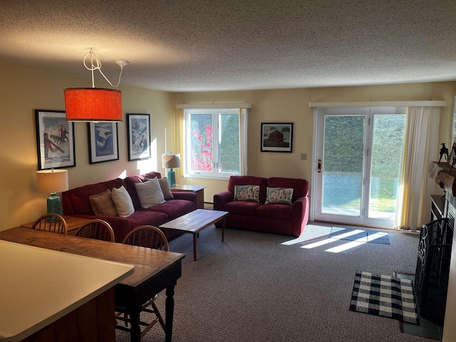 living room featuring carpet, a baseboard heating unit, a fireplace, and a textured ceiling