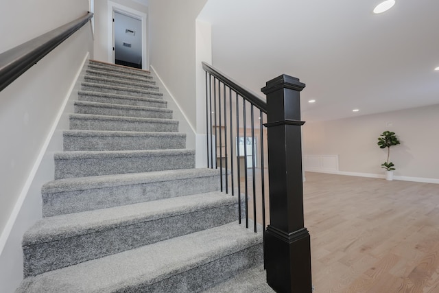 stairway featuring baseboards, recessed lighting, and wood finished floors