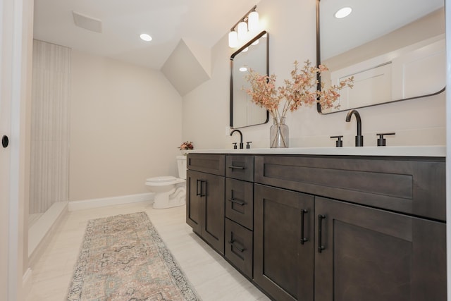 bathroom with baseboards, a sink, toilet, double vanity, and recessed lighting