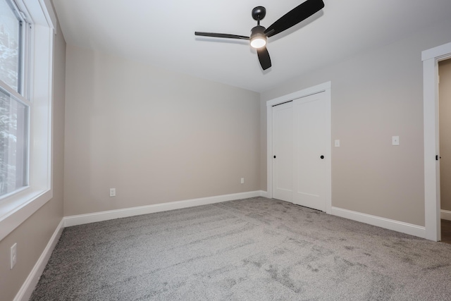 unfurnished bedroom featuring ceiling fan, carpet flooring, a closet, and baseboards