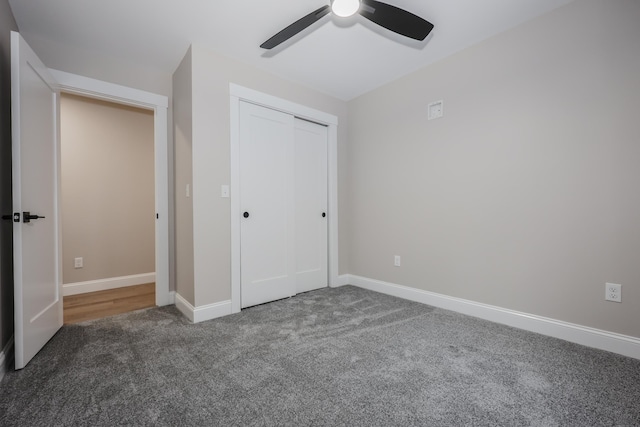 unfurnished bedroom featuring baseboards, a closet, ceiling fan, and carpet floors