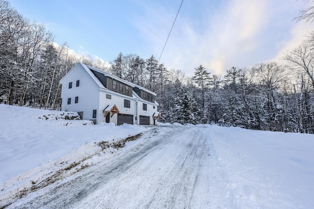 view of snow covered exterior with a garage