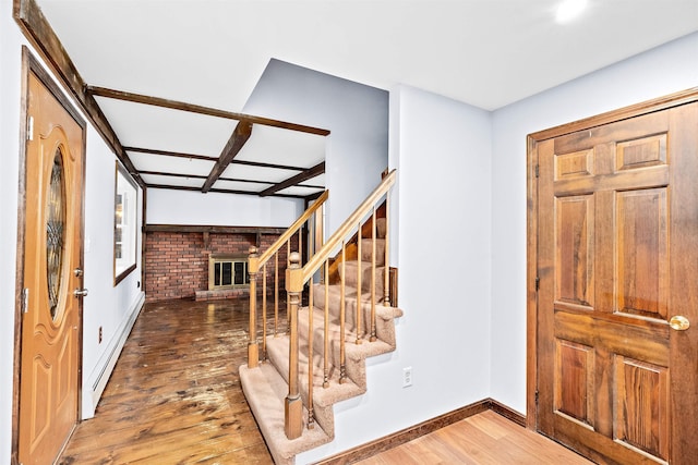 foyer featuring a fireplace, dark hardwood / wood-style flooring, and a baseboard heating unit