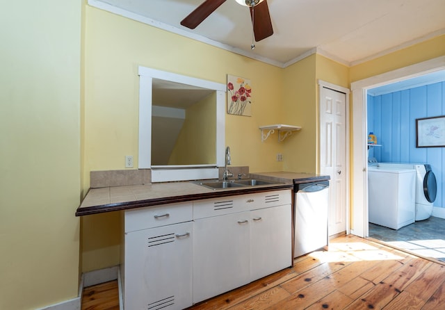 kitchen featuring white cabinetry, sink, stainless steel dishwasher, tile counters, and washing machine and dryer