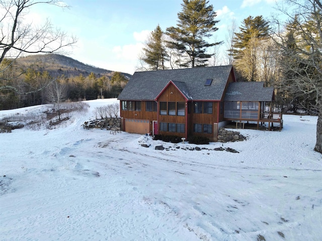 snow covered rear of property with a mountain view