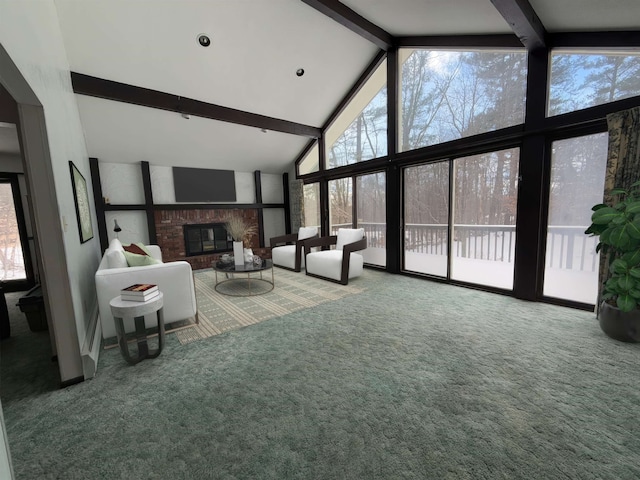 unfurnished living room featuring beamed ceiling, carpet, a healthy amount of sunlight, and a fireplace