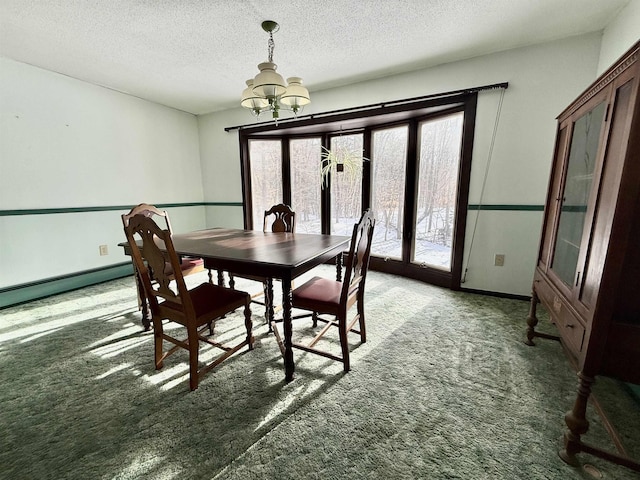 carpeted dining space with an inviting chandelier, baseboard heating, and a textured ceiling