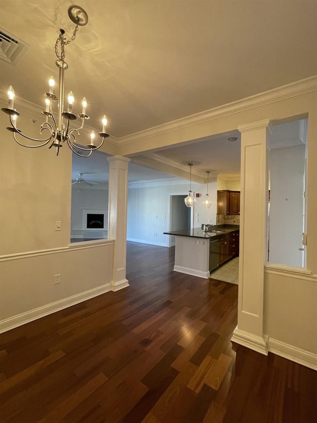 unfurnished living room featuring sink, ornamental molding, dark hardwood / wood-style flooring, and decorative columns