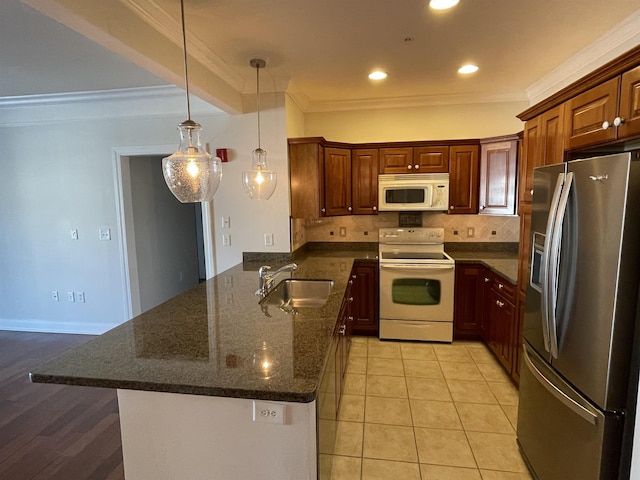 kitchen featuring crown molding, sink, white appliances, and kitchen peninsula