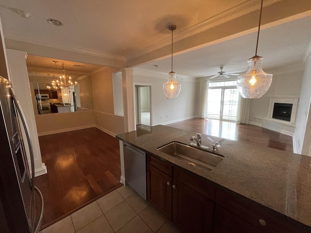 kitchen featuring crown molding, pendant lighting, sink, and stainless steel dishwasher