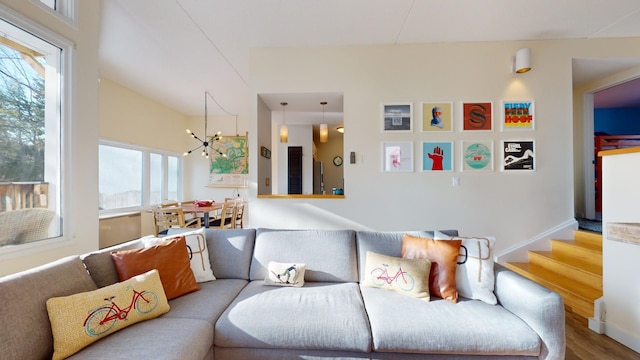 living room with hardwood / wood-style flooring, a healthy amount of sunlight, and an inviting chandelier