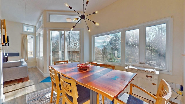 dining space with light hardwood / wood-style floors and a chandelier