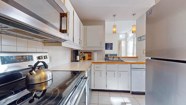 kitchen with appliances with stainless steel finishes, decorative light fixtures, sink, and white cabinets