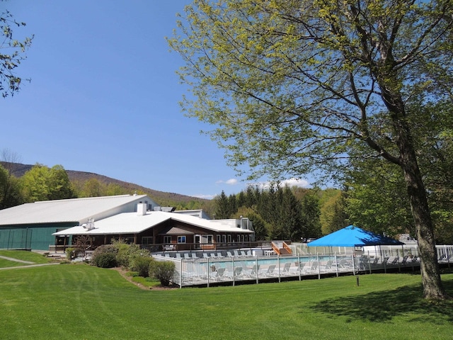 exterior space featuring a pool, a yard, and a mountain view